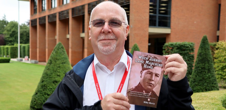John Berry holds up the book When Johnny Came Marching Home.